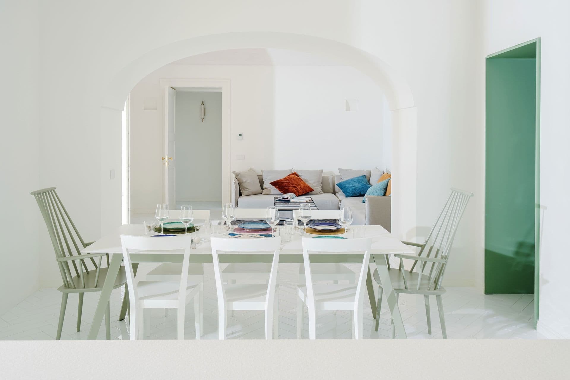 Dining room with white chairs and sea-facing windows at Ocean House, Positano