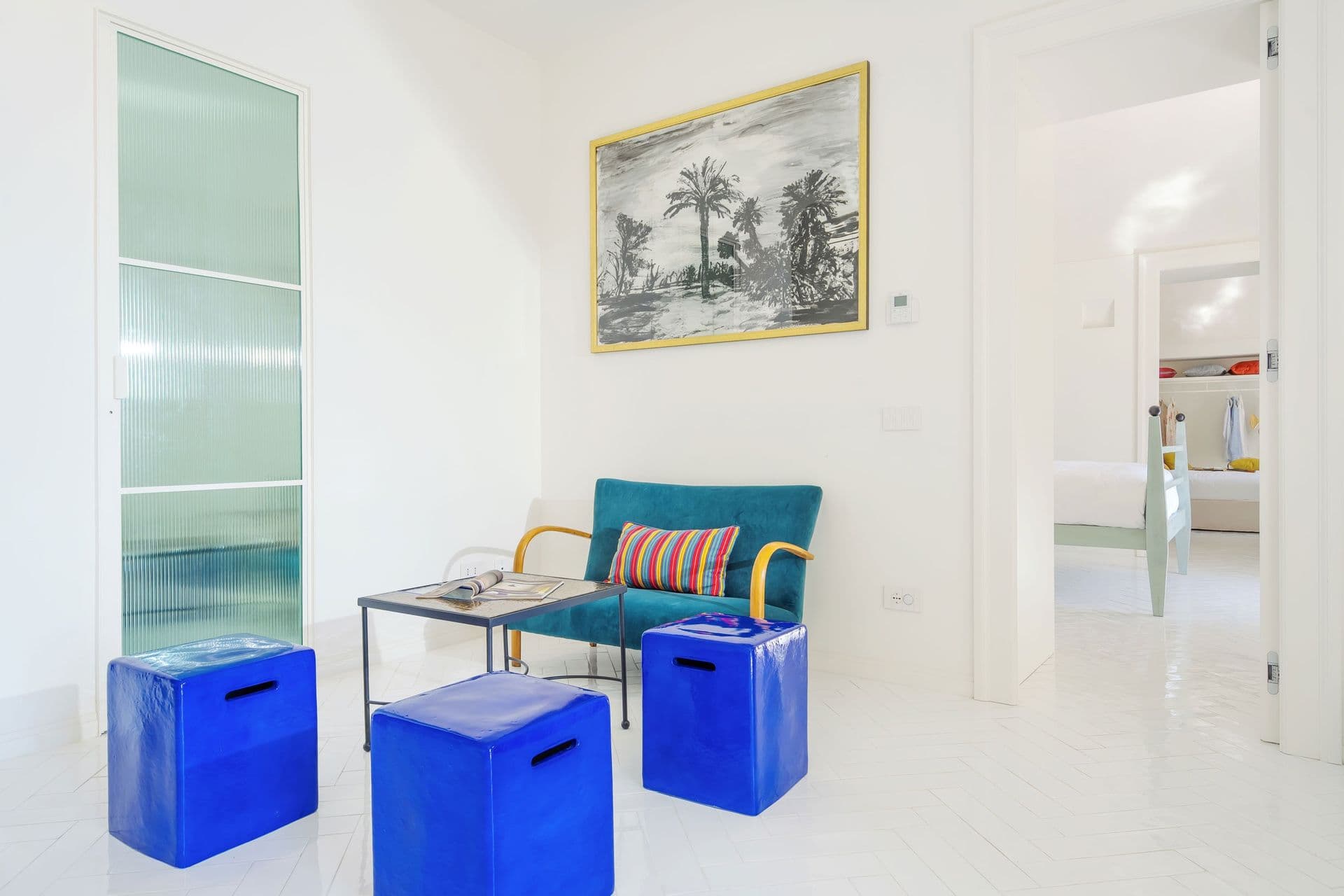 Living space with cobalt blue stools and artwork at Ocean House, Positano
