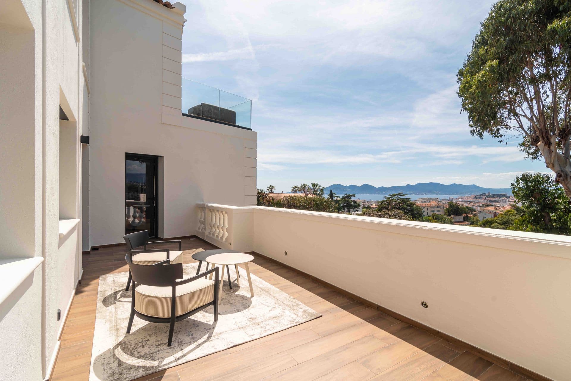 A rooftop terrace with lounge seating overlooking the surrounding hills