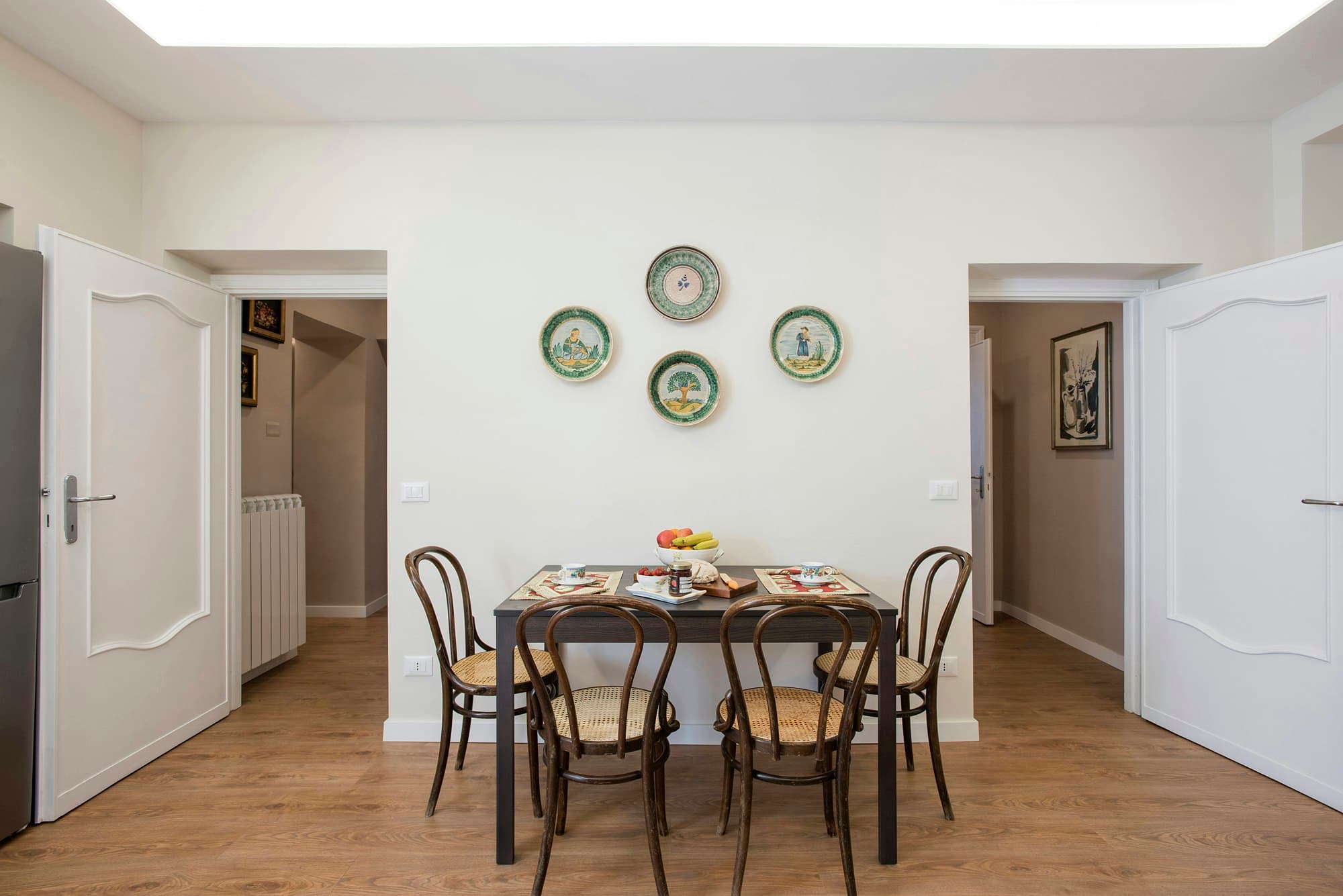 The Eternal dining room with Thonet chairs and ceramic plate display, Rome, Italy