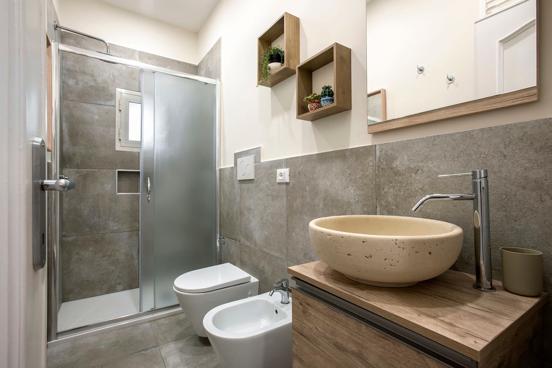 Bathroom with glass shower enclosure and stone vessel sink