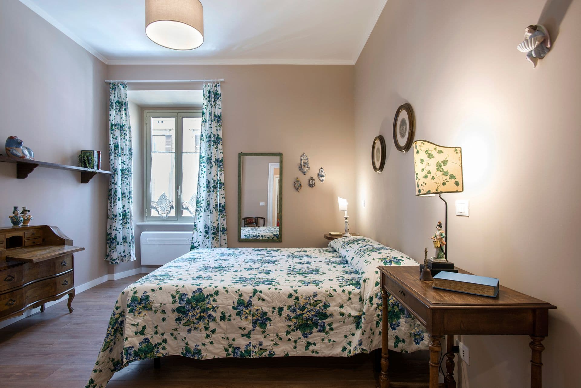 Bedroom with floral bedspread and bedside lamp