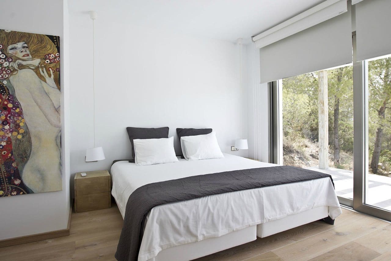 Double bedroom in white with an art canvas and pine views at Between Pines, Ibiza