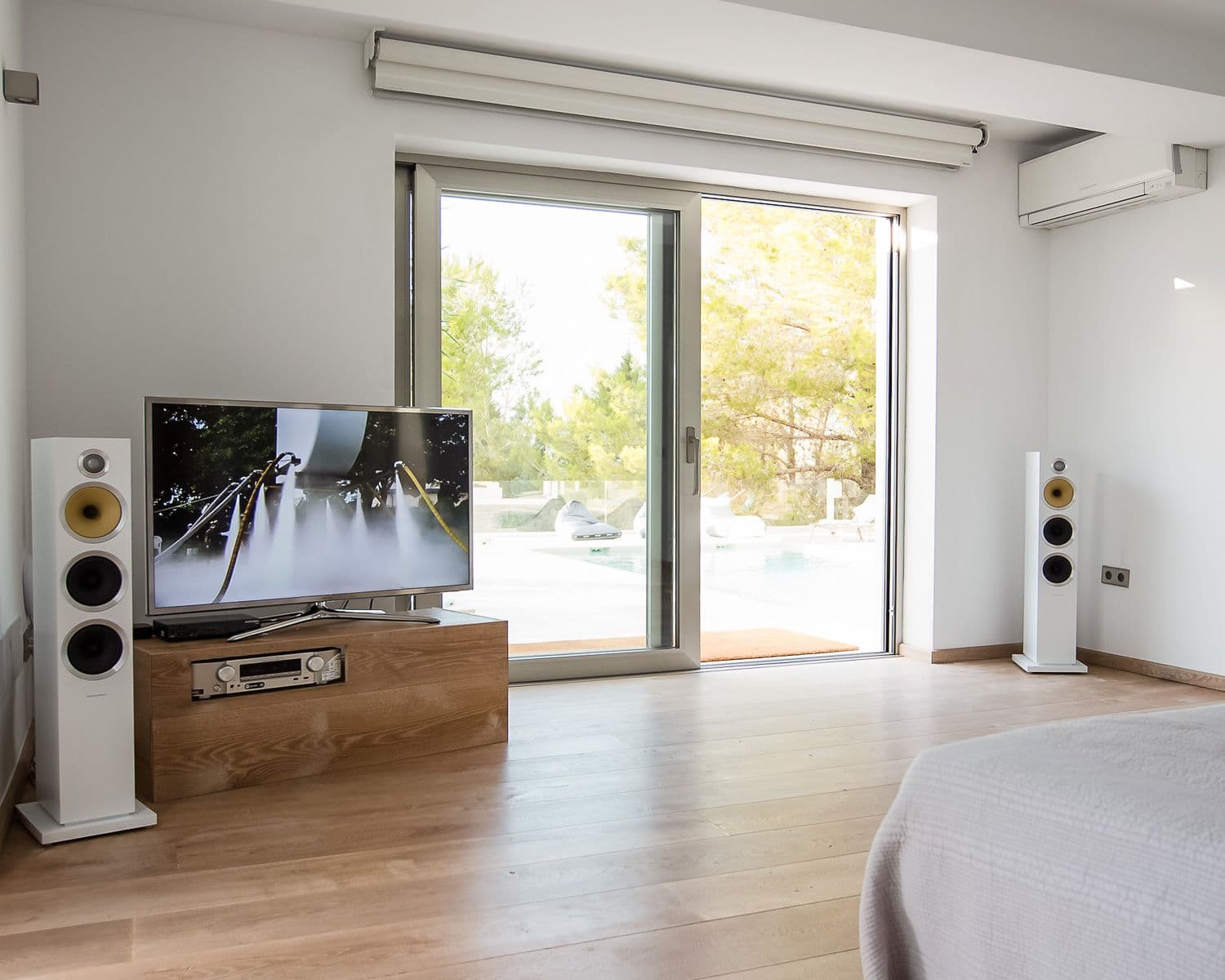 Double bedroom with a television and doors to the pool terrace at Between Pines, Ibiza