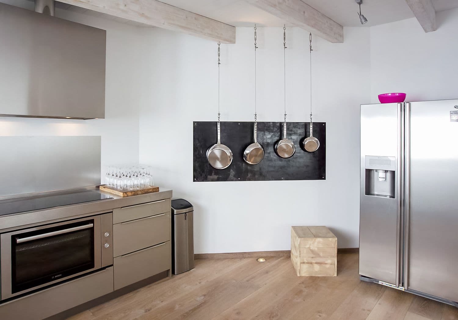 Stainless kitchen with hanging pans and an American fridge at Between Pines, Ibiza