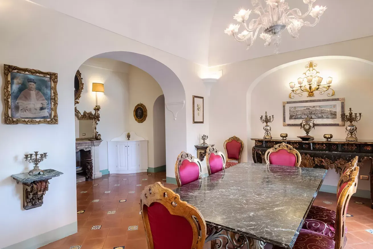 Formal dining room with an ornate table and pink upholstered chairs