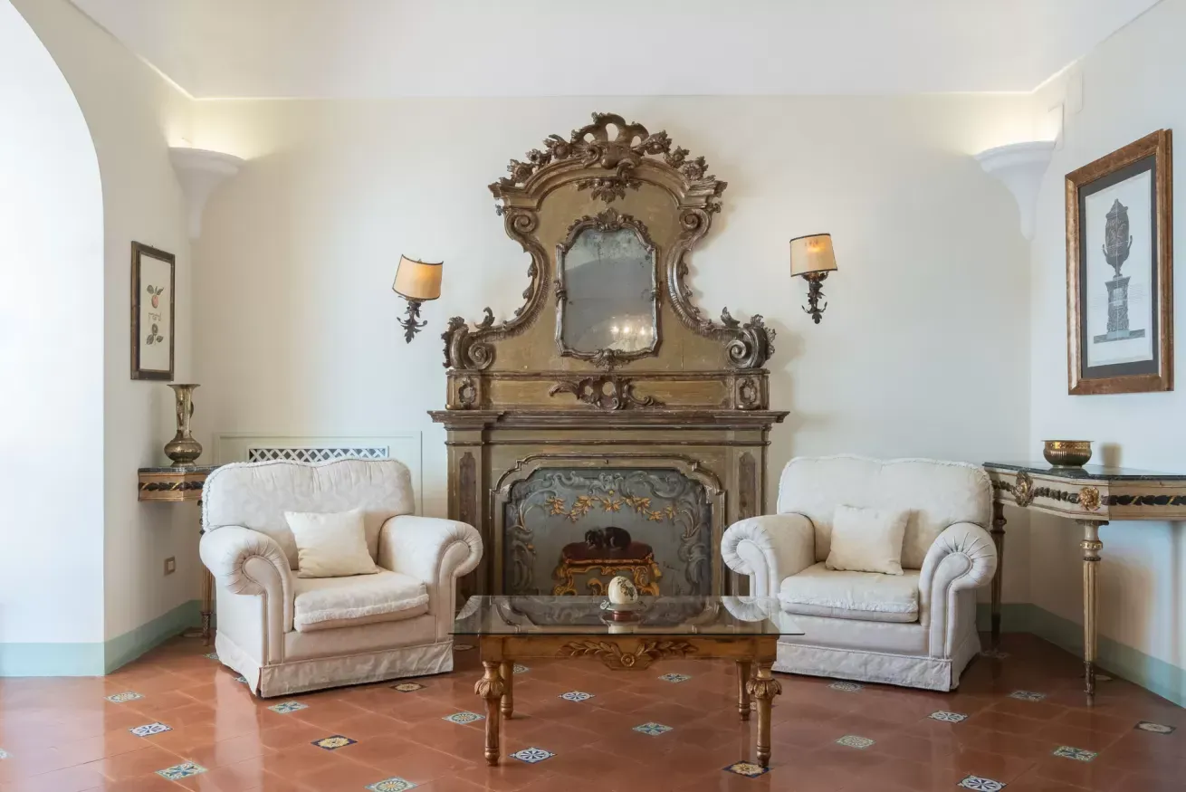 Elegant sitting room with an ornate mirror and antique fireplace