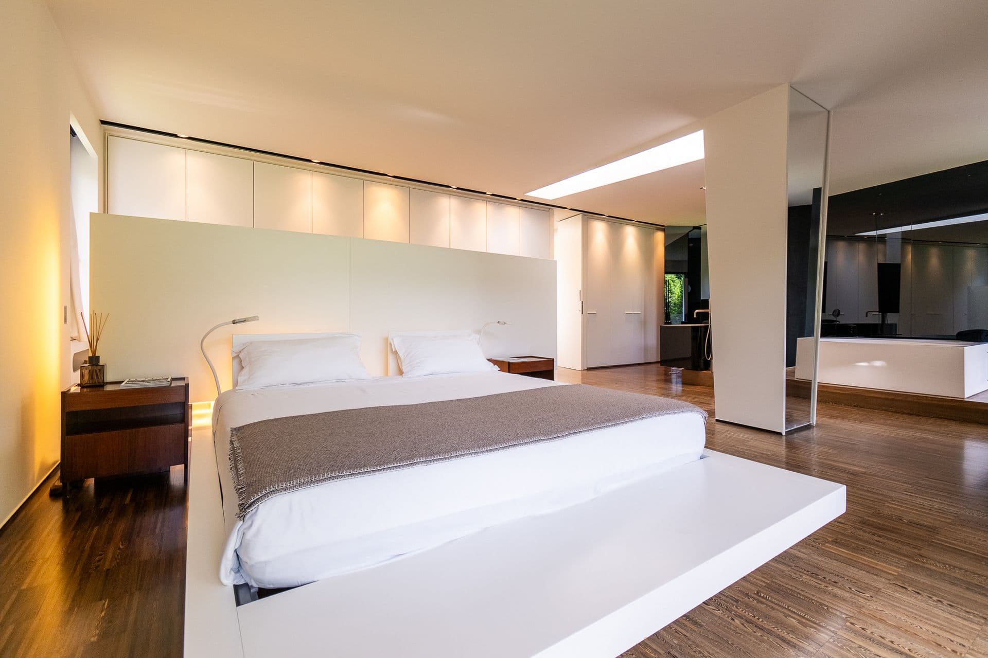 Double bedroom with a white platform bed and mirrored wall at Elegant Lake Manor, Cernobbio