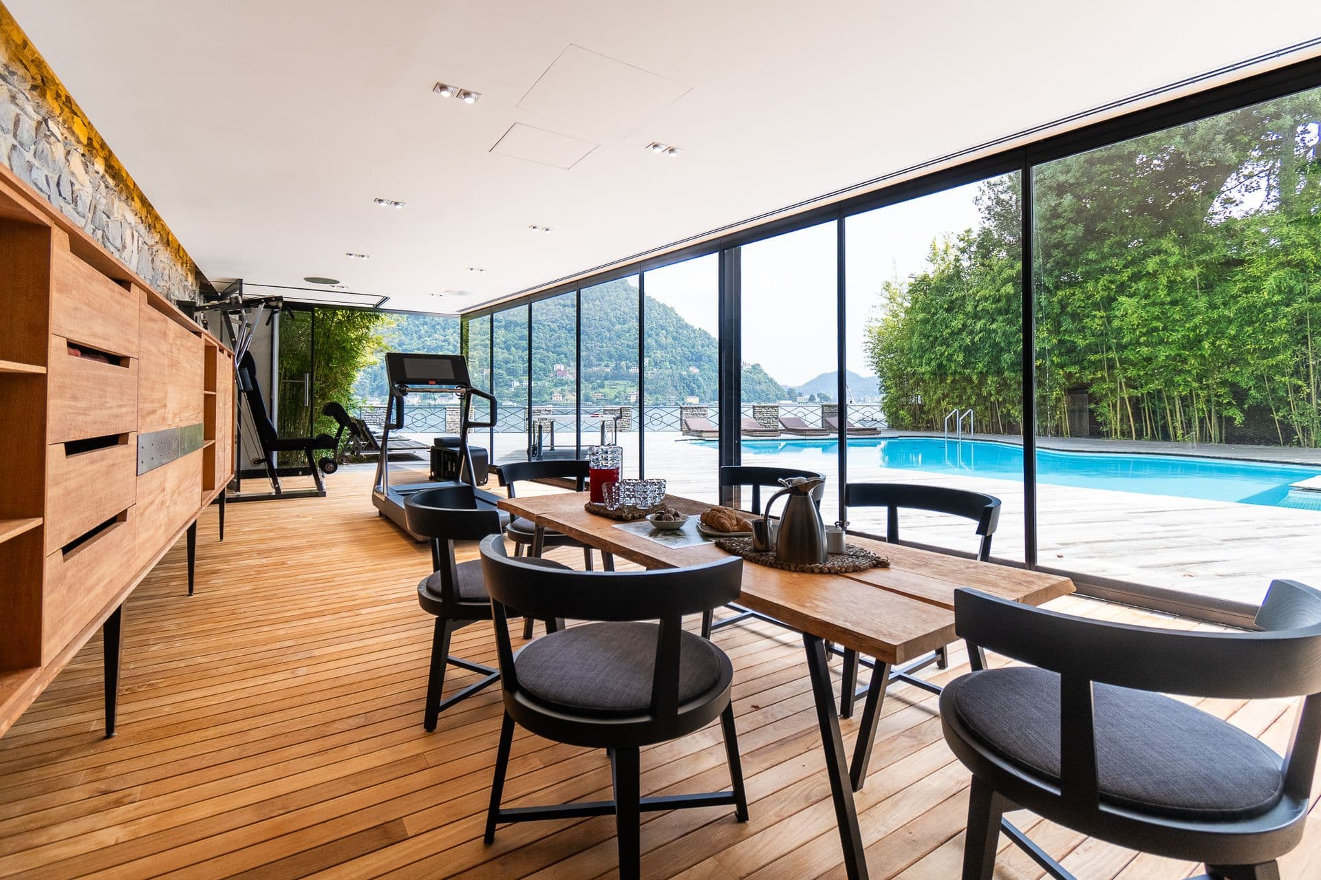 Dining table with designer chairs beside the pool-view terrace at Elegant Lake Manor, Cernobbio