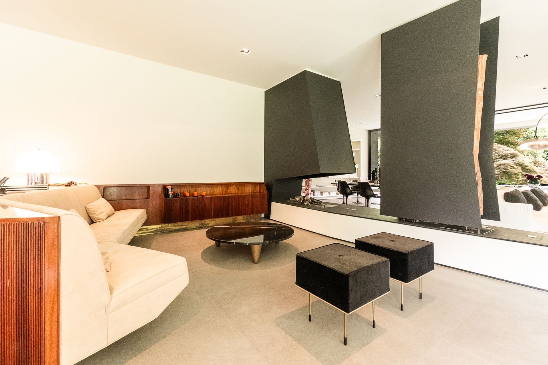 Living room with a suspended steel fireplace and timber feature wall at Elegant Lake Manor, Cernobbio