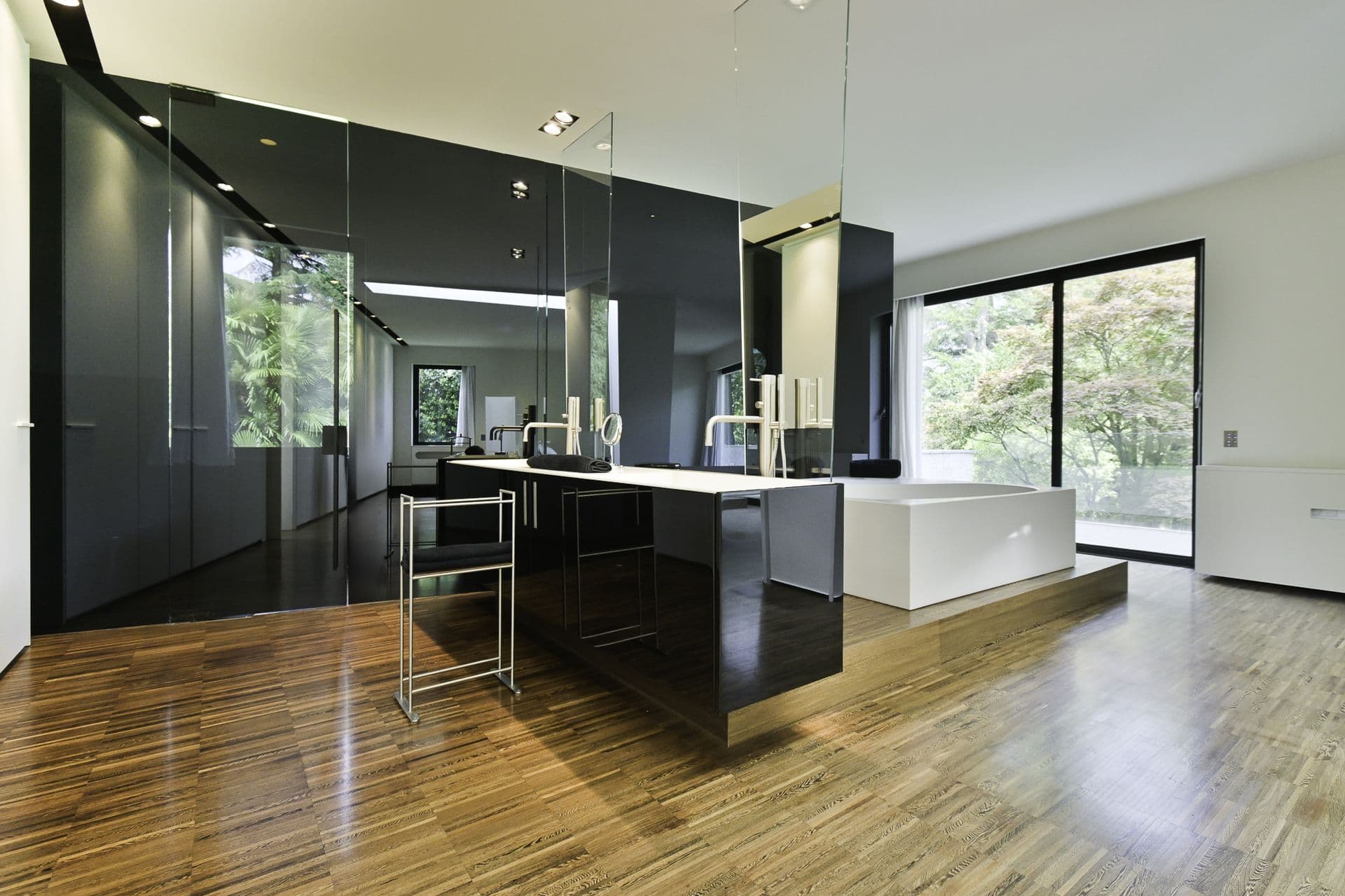 Black lacquer kitchen with an island on timber floors at Elegant Lake Manor, Cernobbio