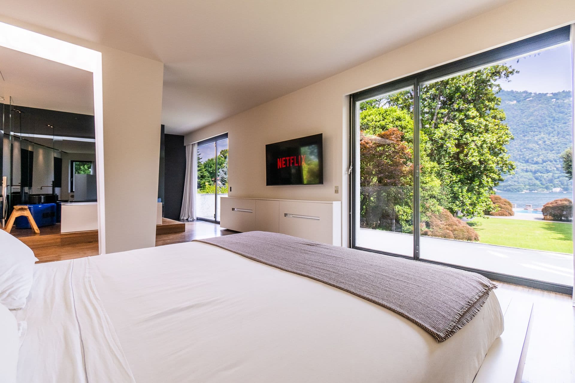 Master bedroom with sliding glass onto a lake view at Elegant Lake Manor, Cernobbio