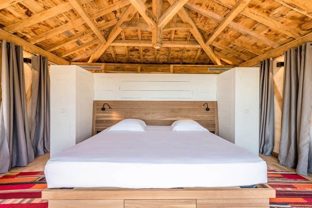 Bedroom with a vaulted wood-beam ceiling and crisp white bedding
