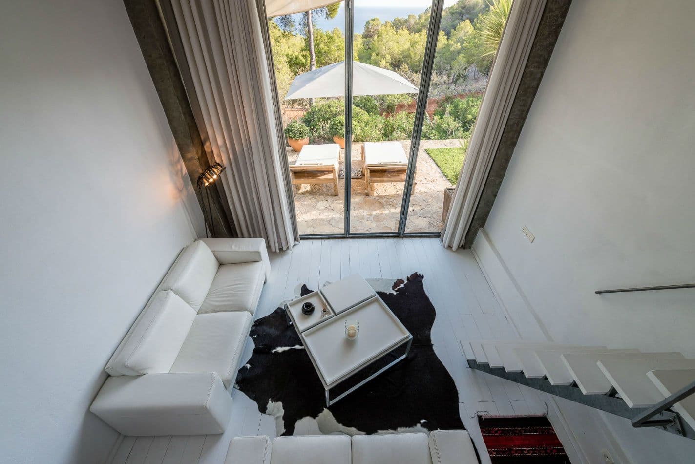 Cosy lounge corner with white sofas and a cowhide rug