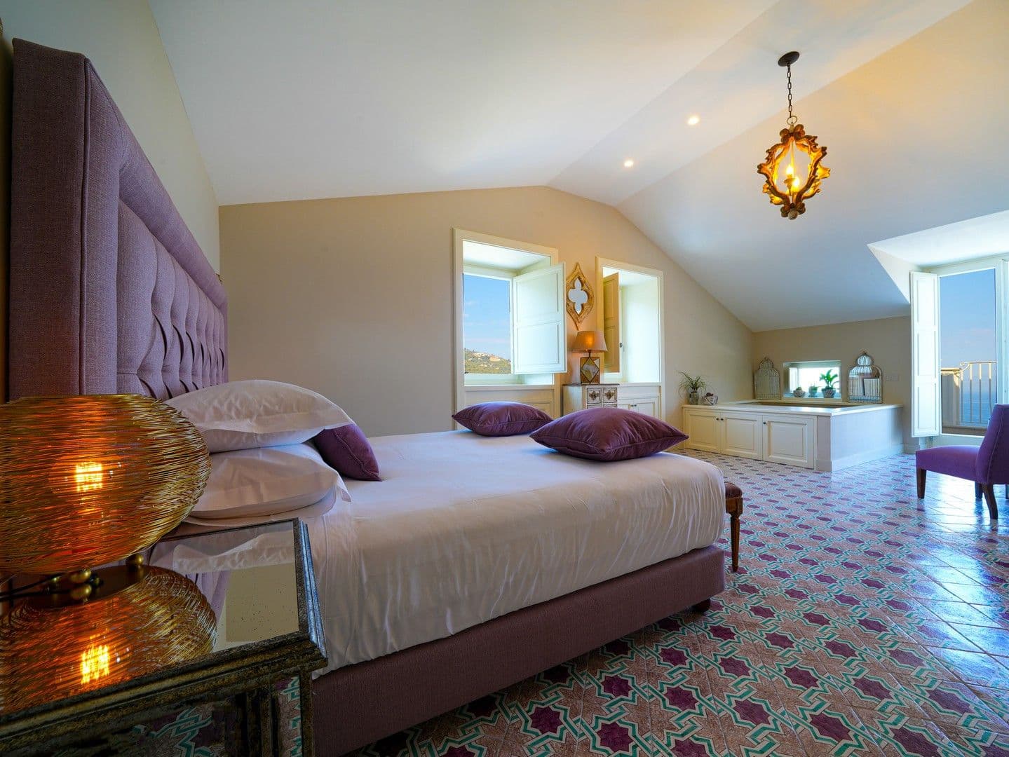 Bedroom suite with a plum velvet bed and an open bath alcove on majolica tiles at Casarlano Sunsets, Sorrento