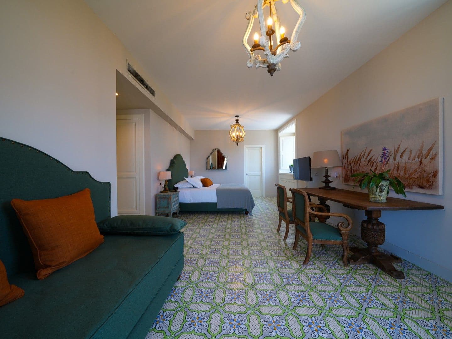 Double bedroom with a teal bed, orange accents and majolica tiles at Casarlano Sunsets, Sorrento