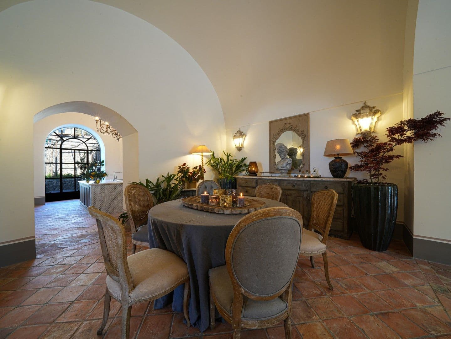 Vaulted dining room with a round table and wrought-iron chandelier at Casarlano Sunsets, Sorrento