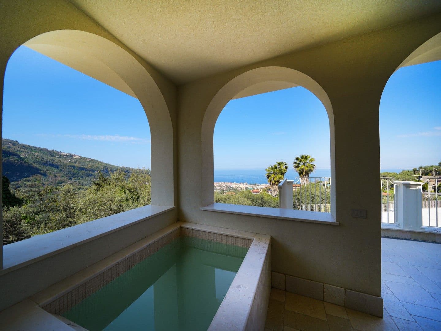 Arched loggia with a plunge pool framing a sea view at Casarlano Sunsets, Sorrento