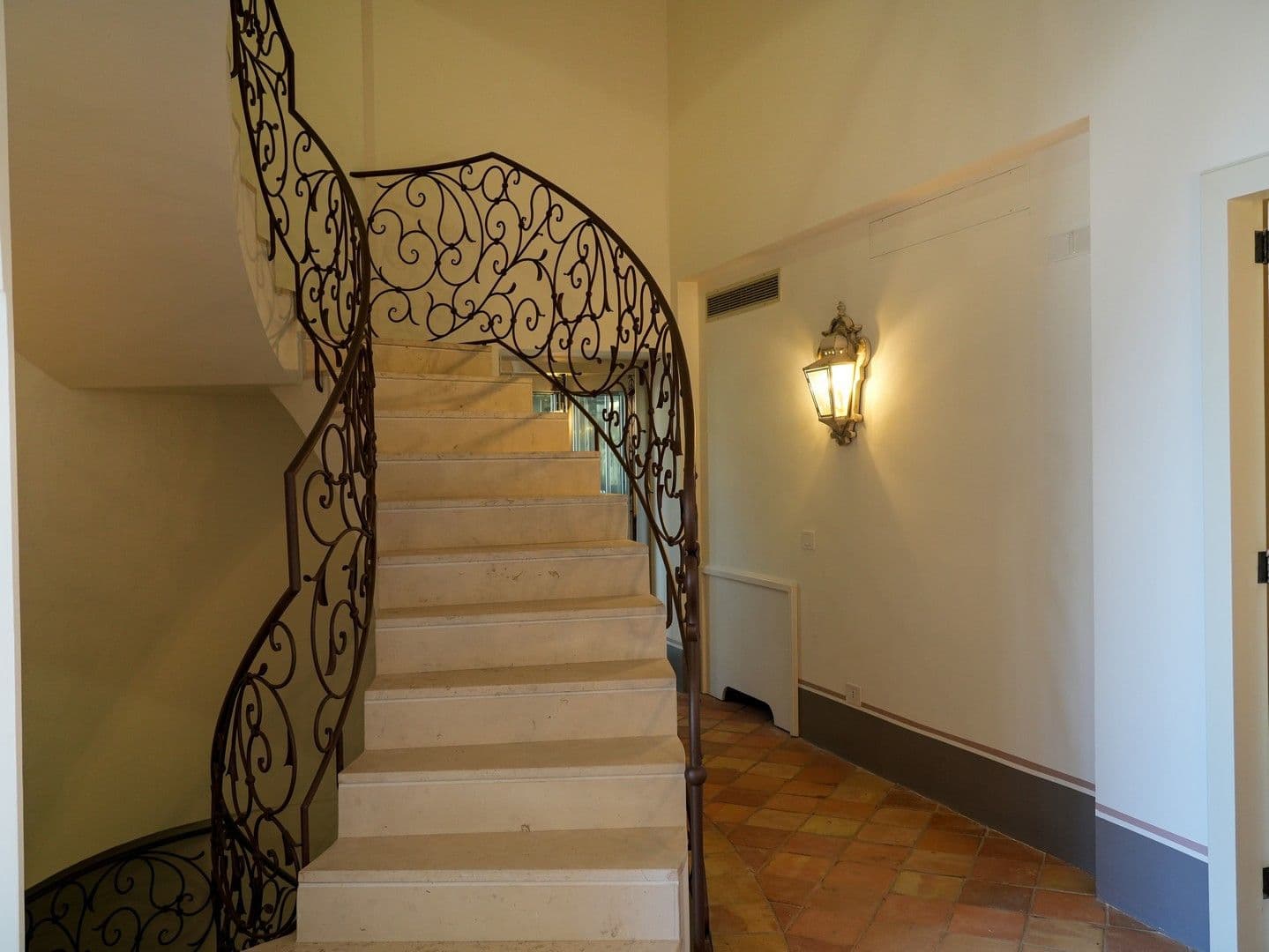 Stone spiral staircase with an ornate wrought-iron balustrade at Casarlano Sunsets, Sorrento