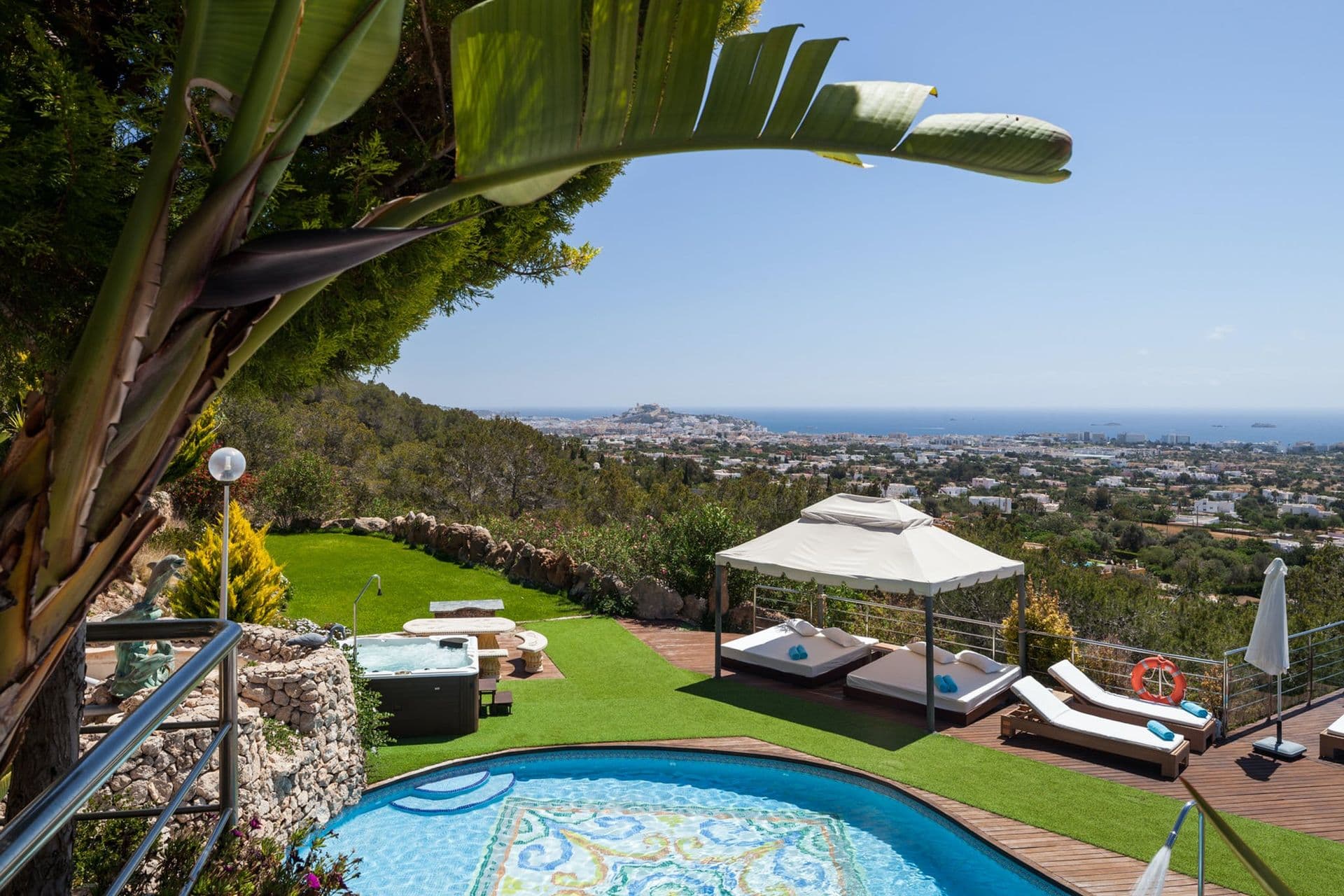 Sun loungers on a terraced garden with panoramic views over the Ibizan hills to the sea