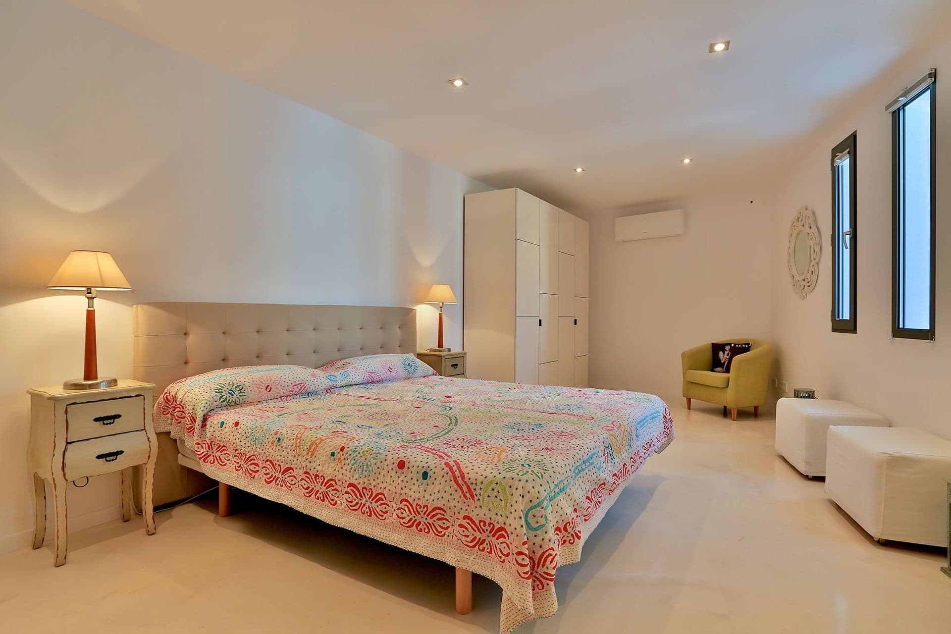 Bedroom with a colourful patterned bedspread and armchair at Hazy Island View