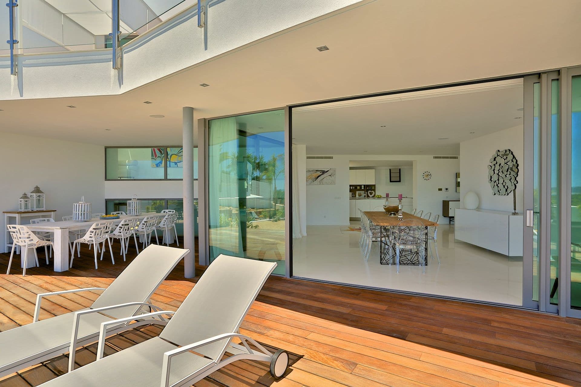 Covered timber deck with sun loungers and glass balustrade at Hazy Island View