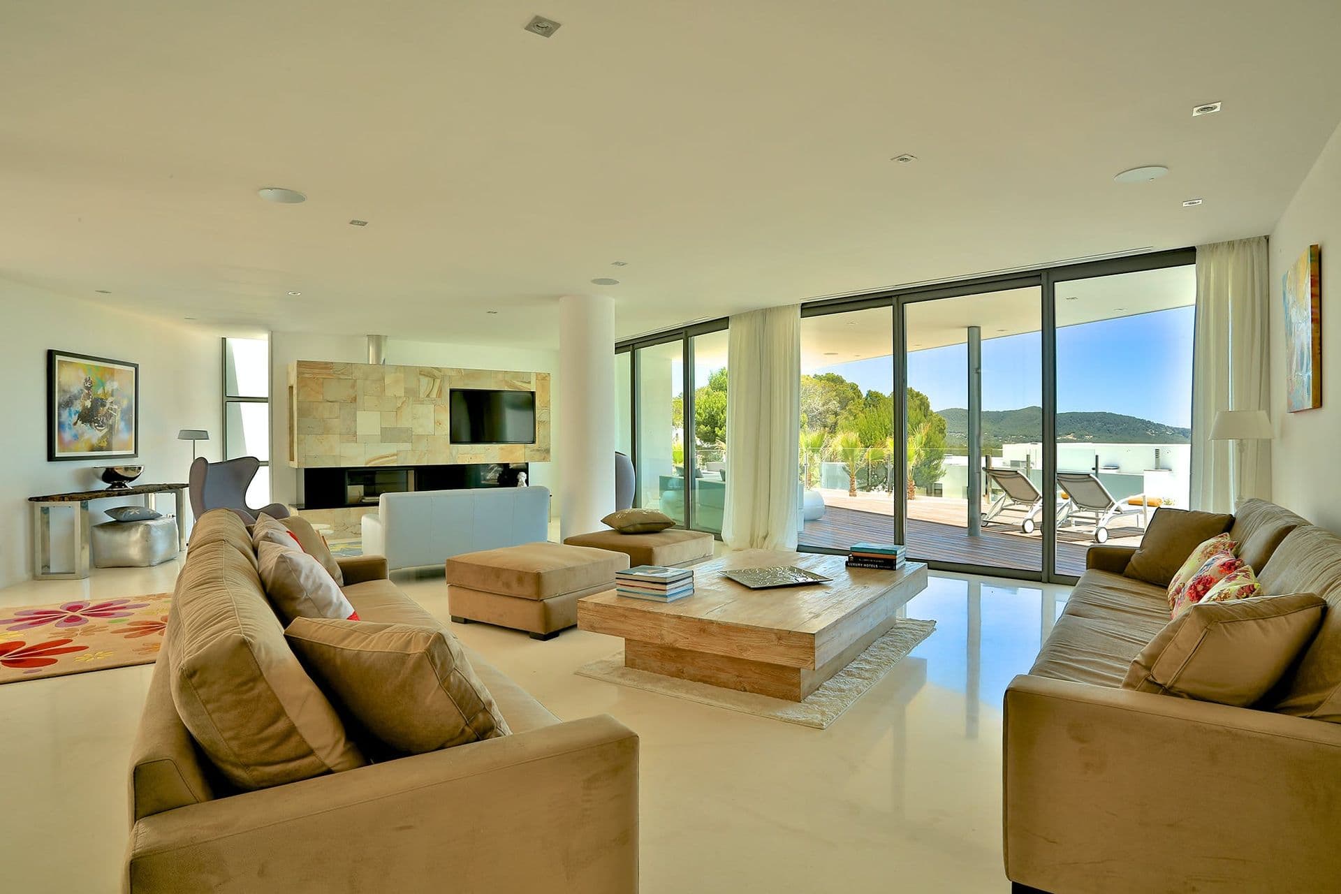 Open-plan living room with taupe sofas and sea-facing windows at Hazy Island View