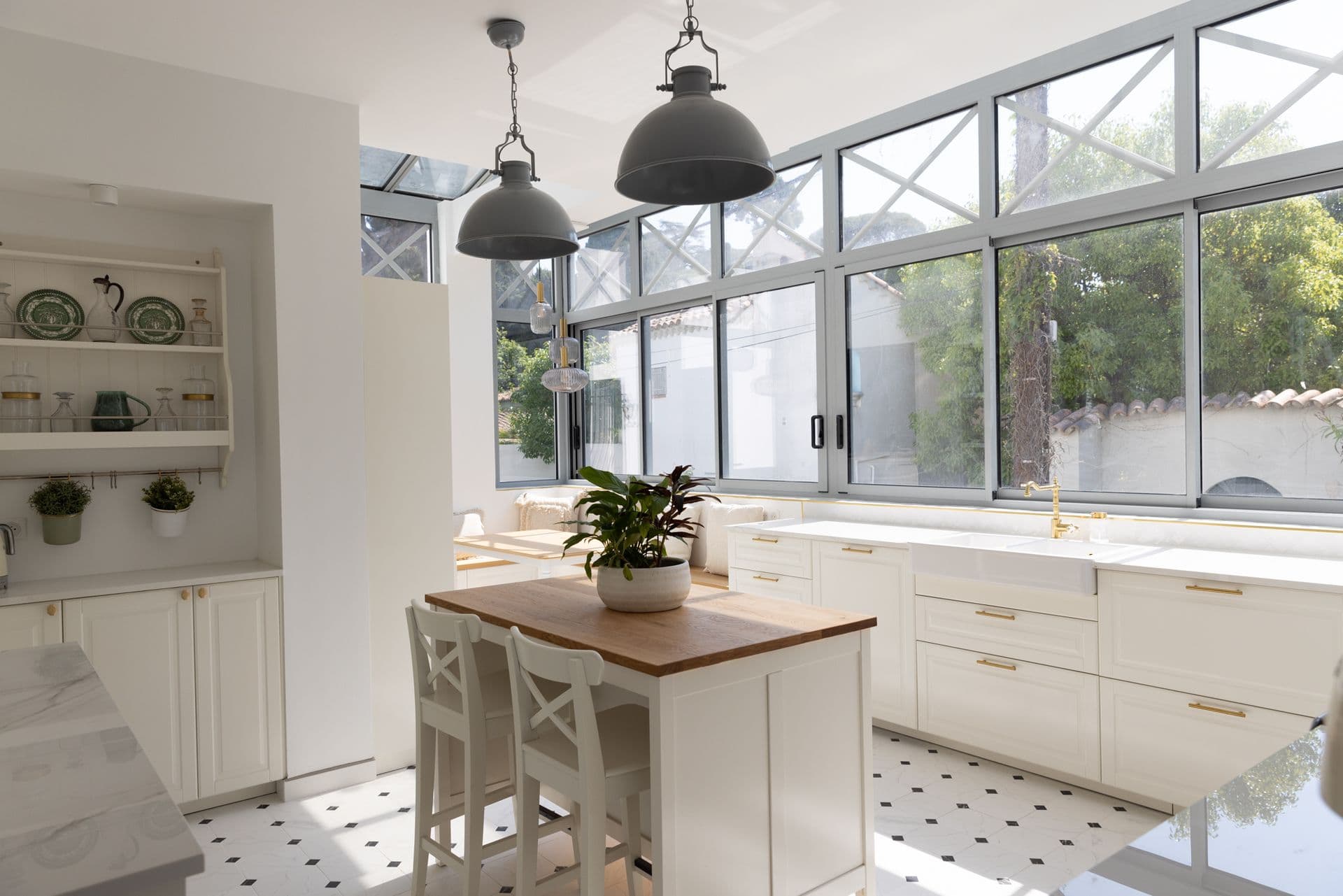 White kitchen with industrial pendants and a wall of windows at Cote D'Azur Sunshine, Antibes