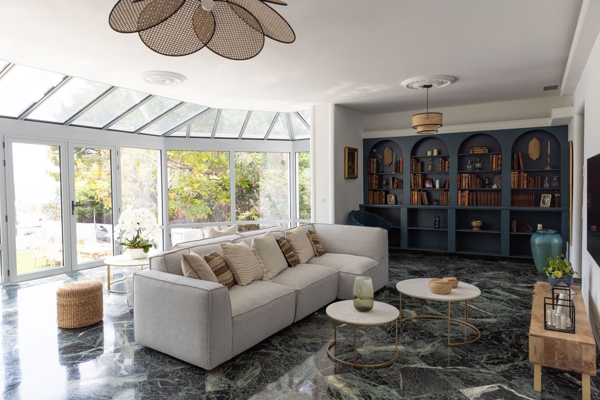 Living room with a stone fireplace and cream sofa beside the conservatory windows at Cote D'Azur Sunshine, Antibes
