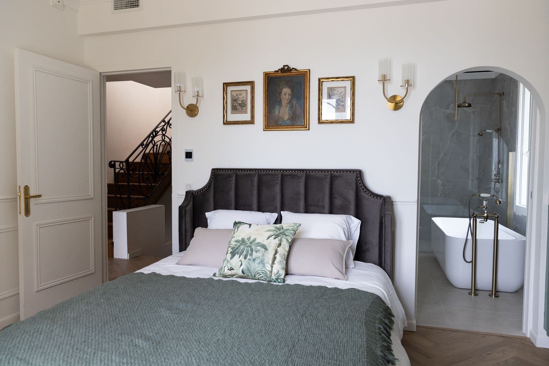Master bedroom with a grey velvet headboard and an open bathtub at Cote D'Azur Sunshine, Antibes