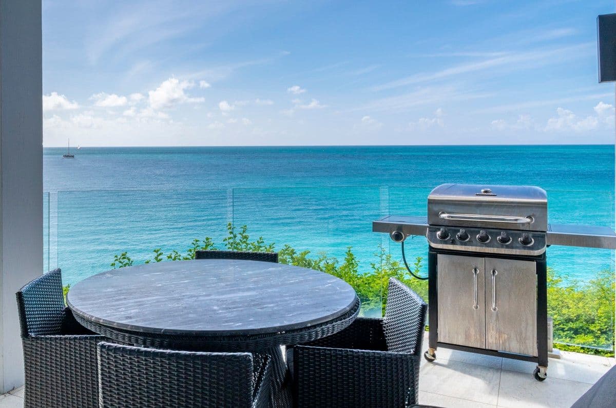 Private balcony with a barbecue and dining table over the sea at Views in the Tropics