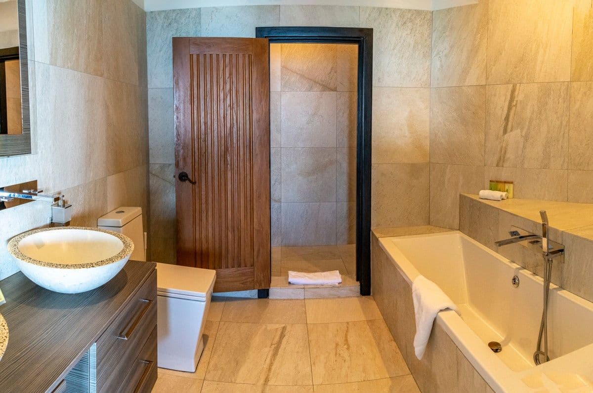 En-suite bathroom with a stone bath and bowl basin at Views in the Tropics, Antigua