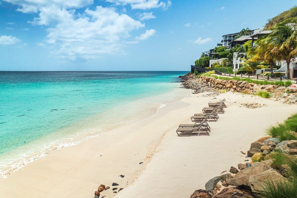 White-sand beach and turquoise water below the resort at Views in the Tropics, Antigua