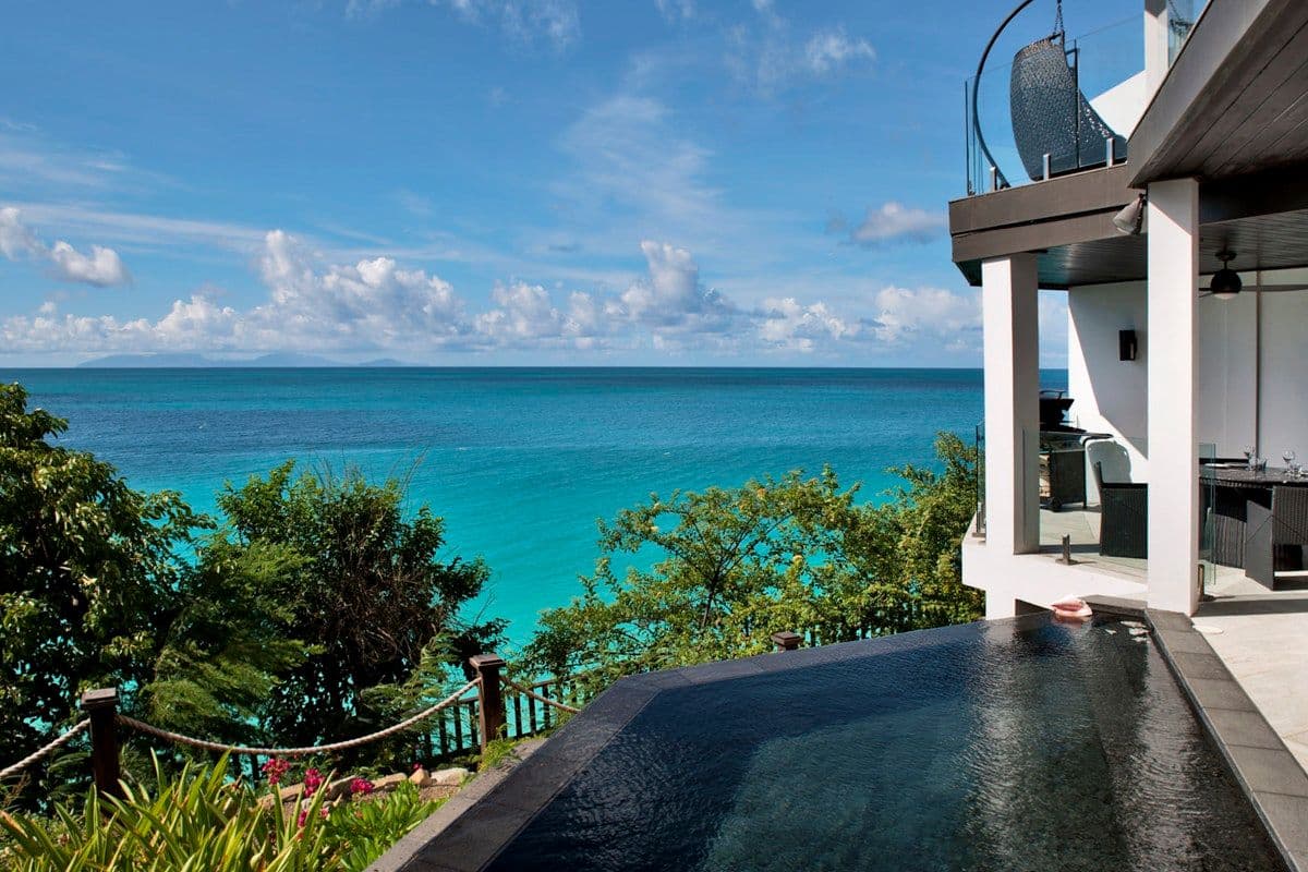 Infinity pool edge merging with the turquoise sea at Views in the Tropics, Antigua