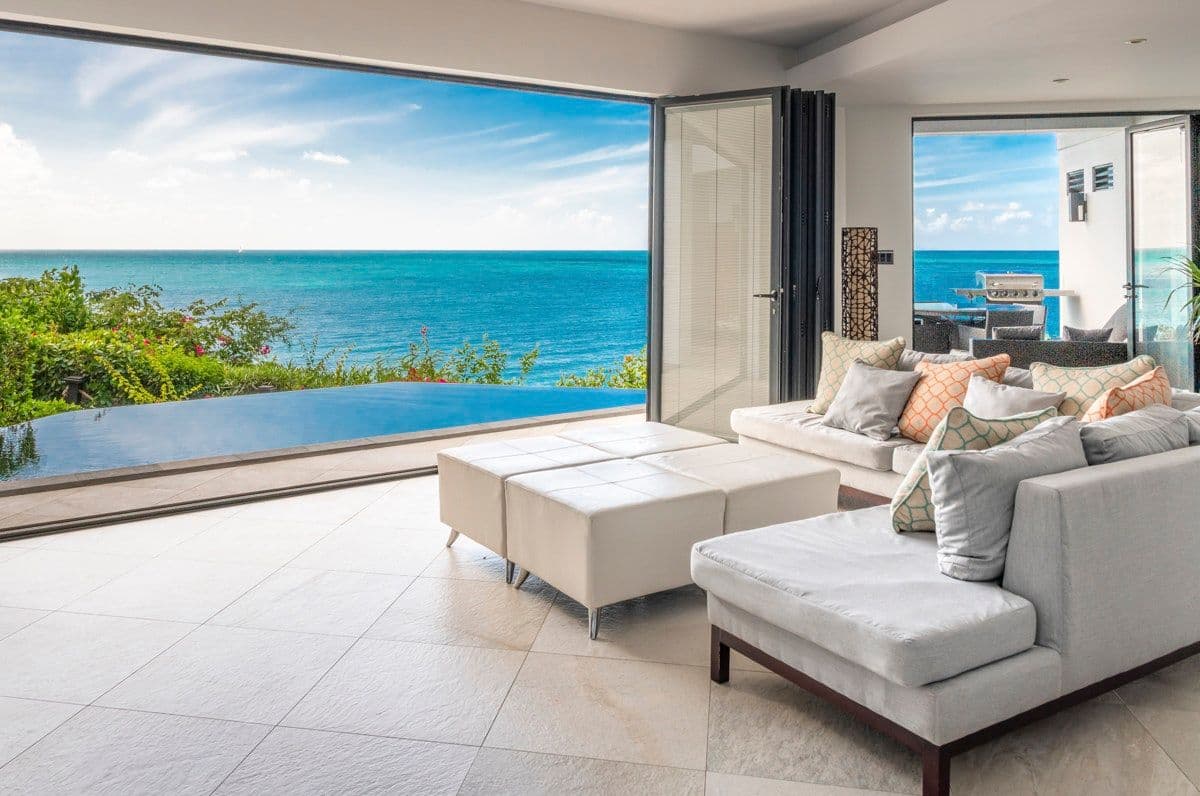 Living room opening to the infinity pool and turquoise sea at Views in the Tropics, Antigua