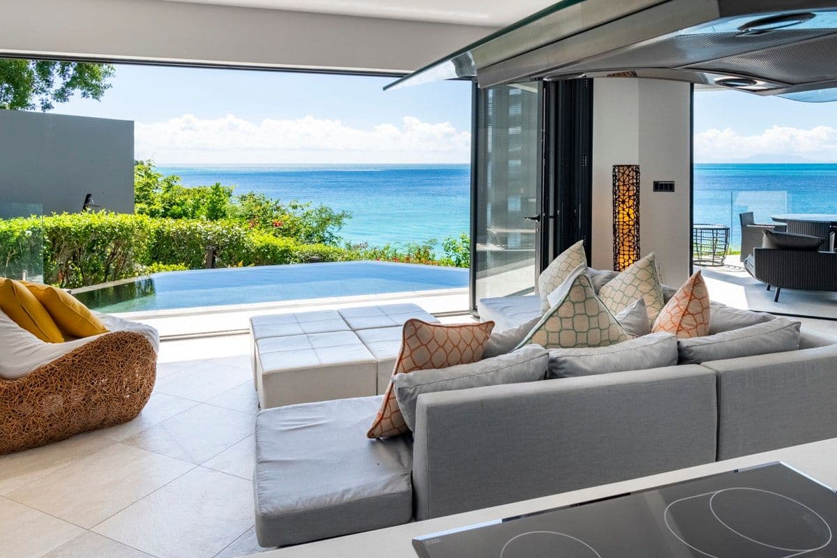 Open-plan living room opening to the pool and sea at Views in the Tropics, Antigua