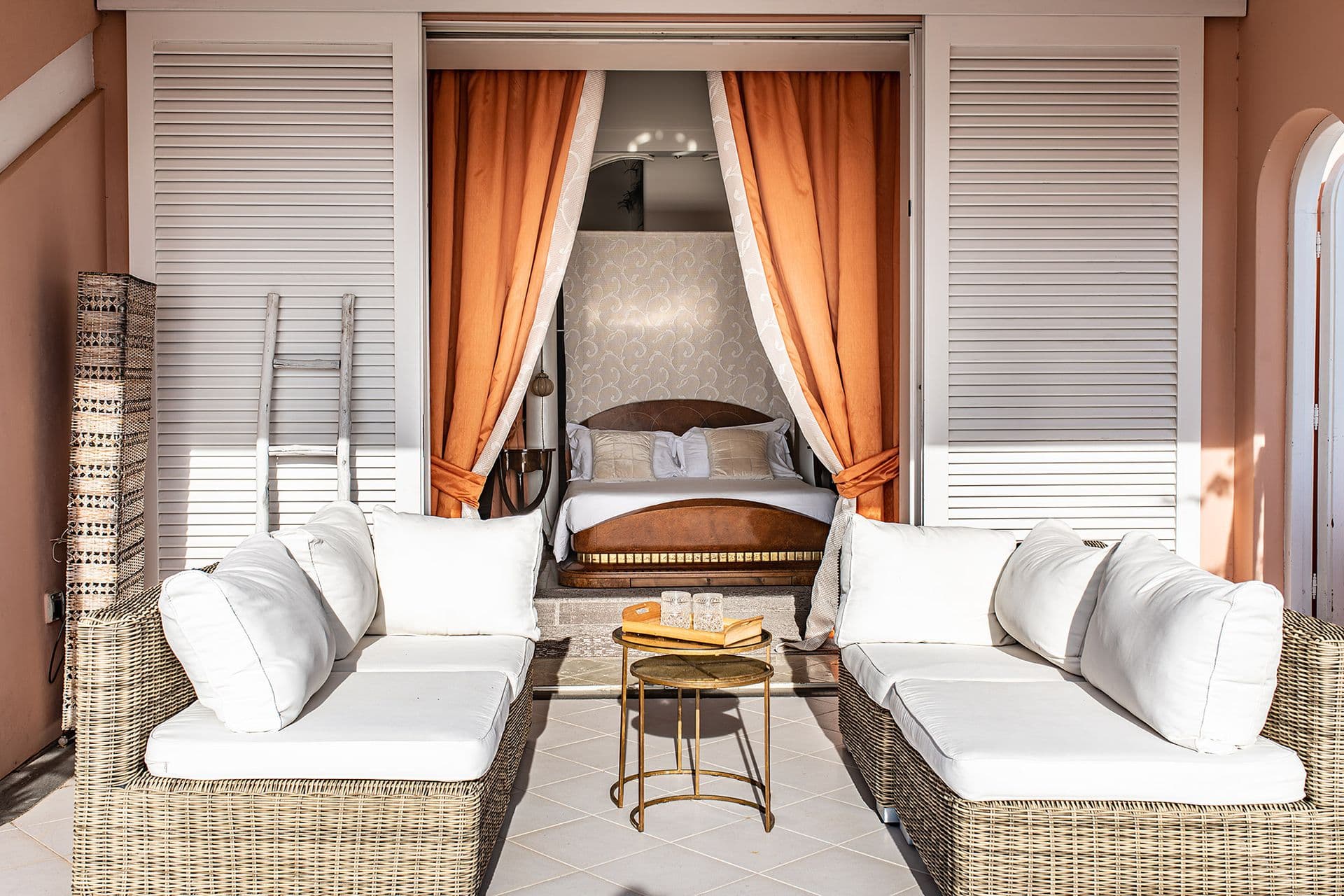 Bedroom with a pair of upholstered daybeds and coral drapes