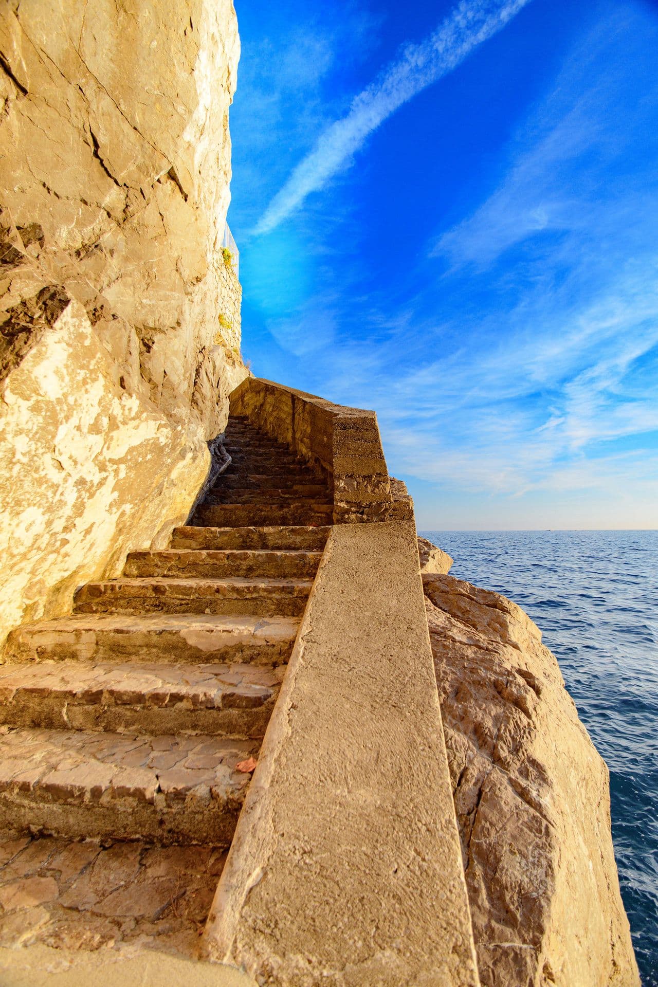 Stone steps cut into the cliffside leading down towards the sea
