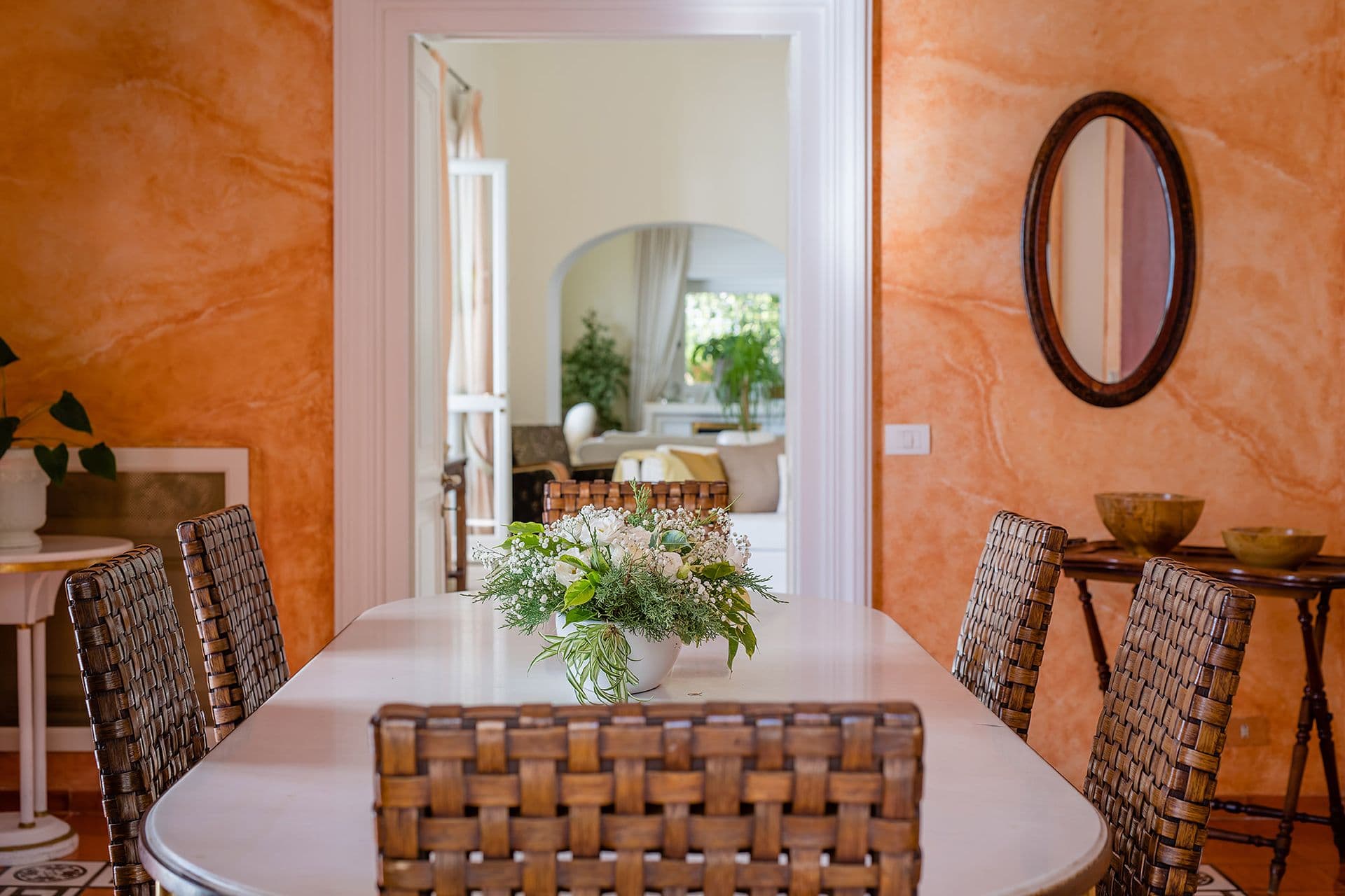 Indoor dining room with terracotta walls and a table set for six