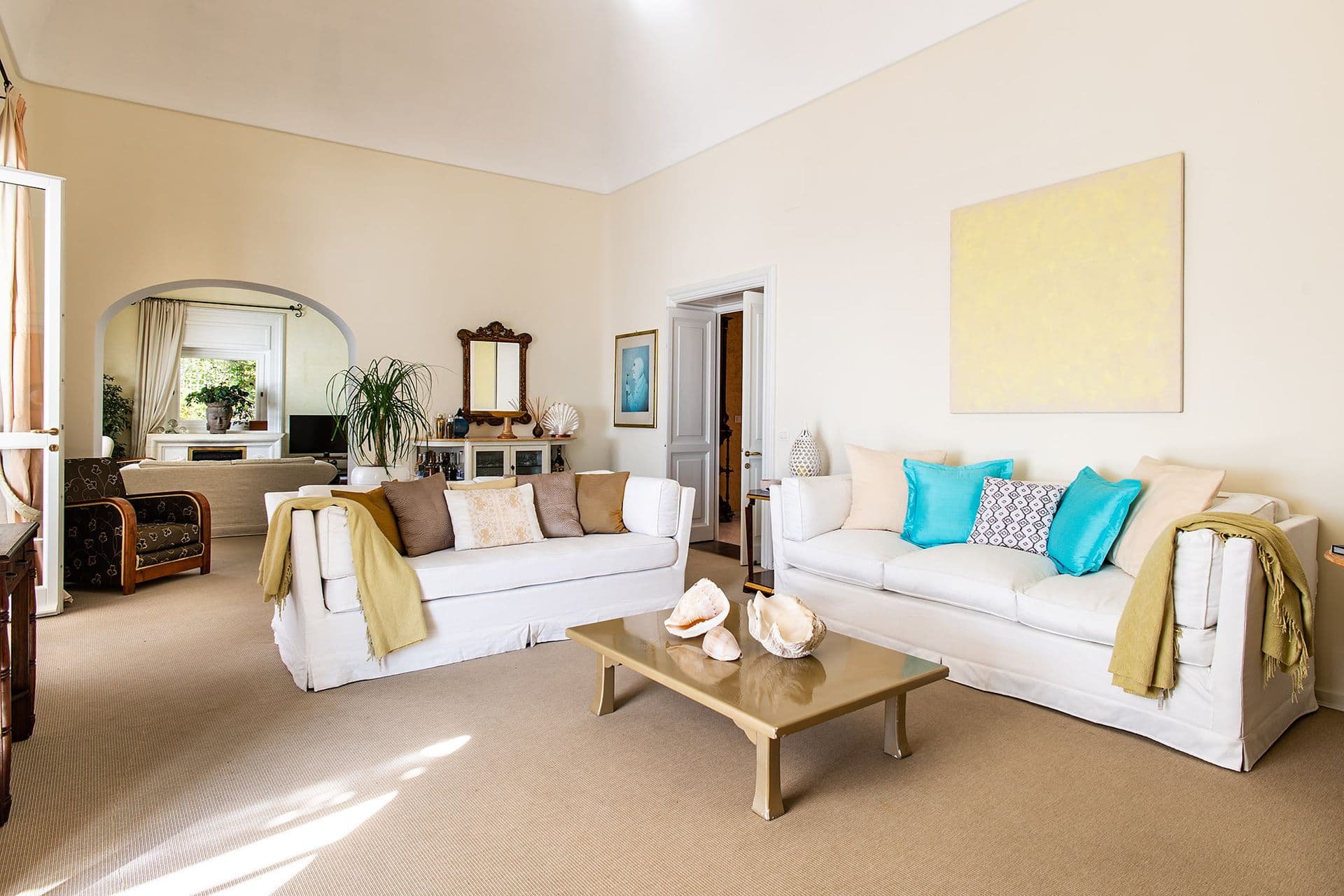 Bright sitting room with white sofas and a garden-facing window