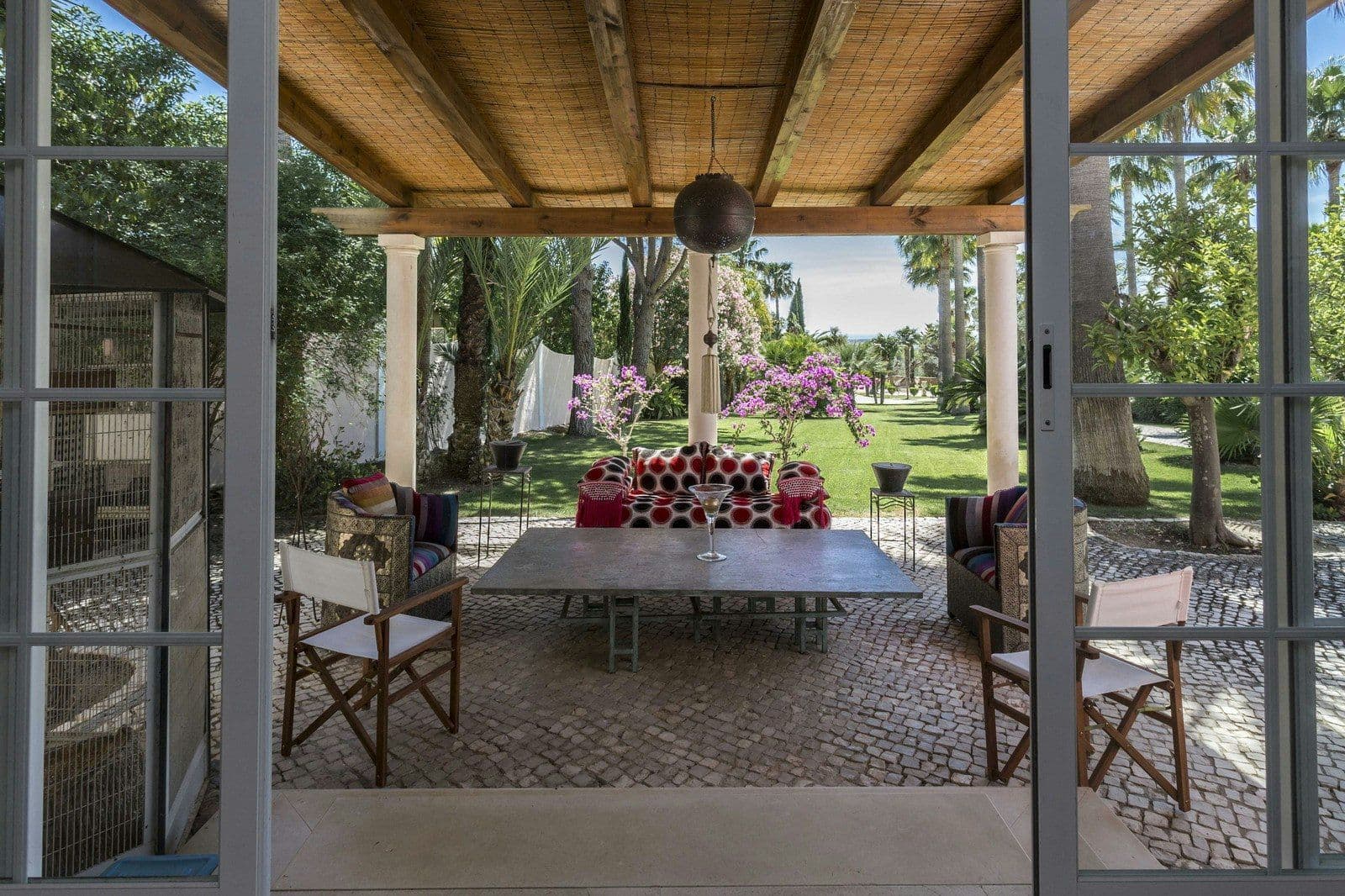 Covered terrace with a dining table looking over the gardens at Your Algarve Oasis