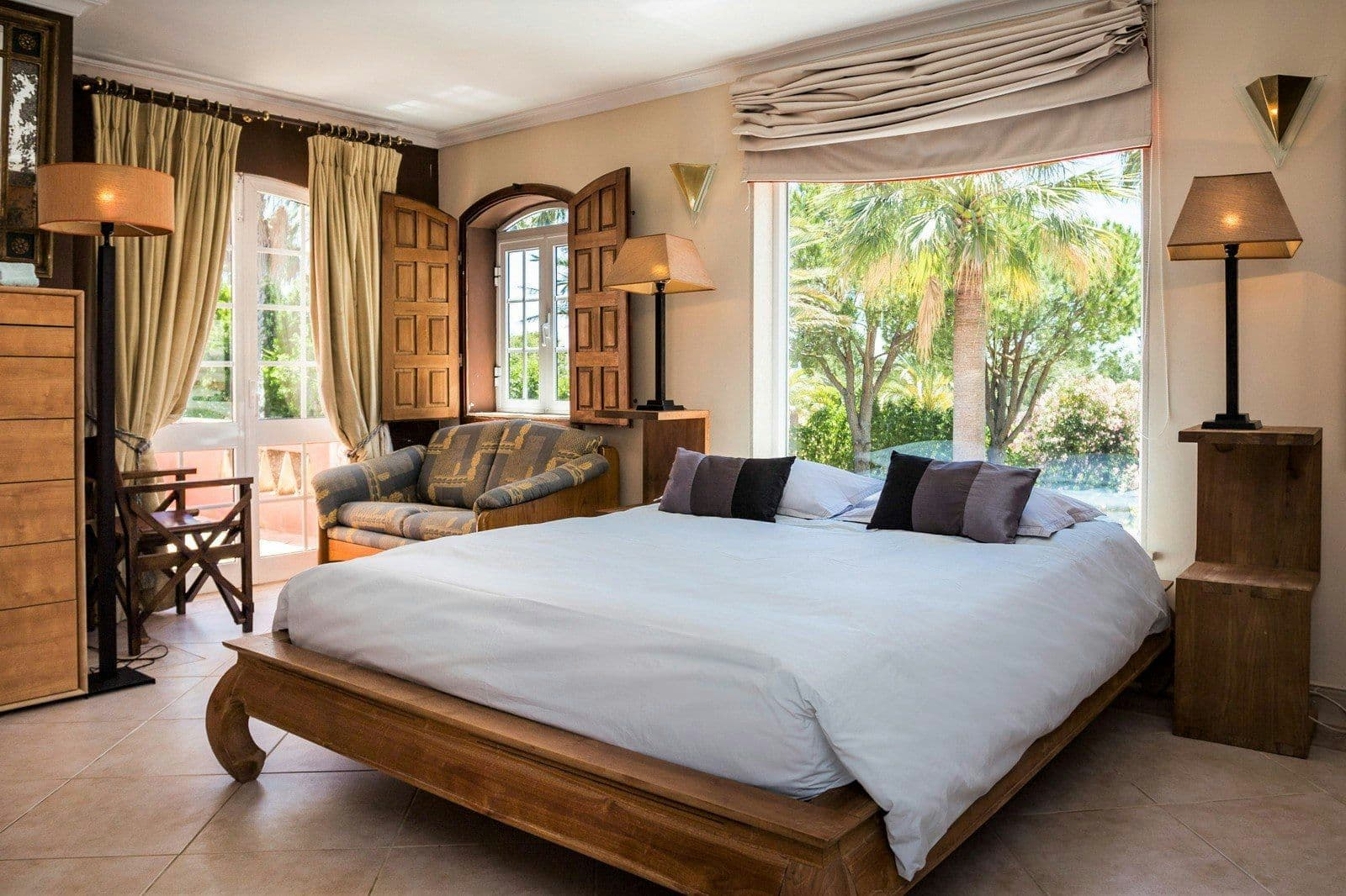 Bedroom opening to a terrace and palm garden at Your Algarve Oasis