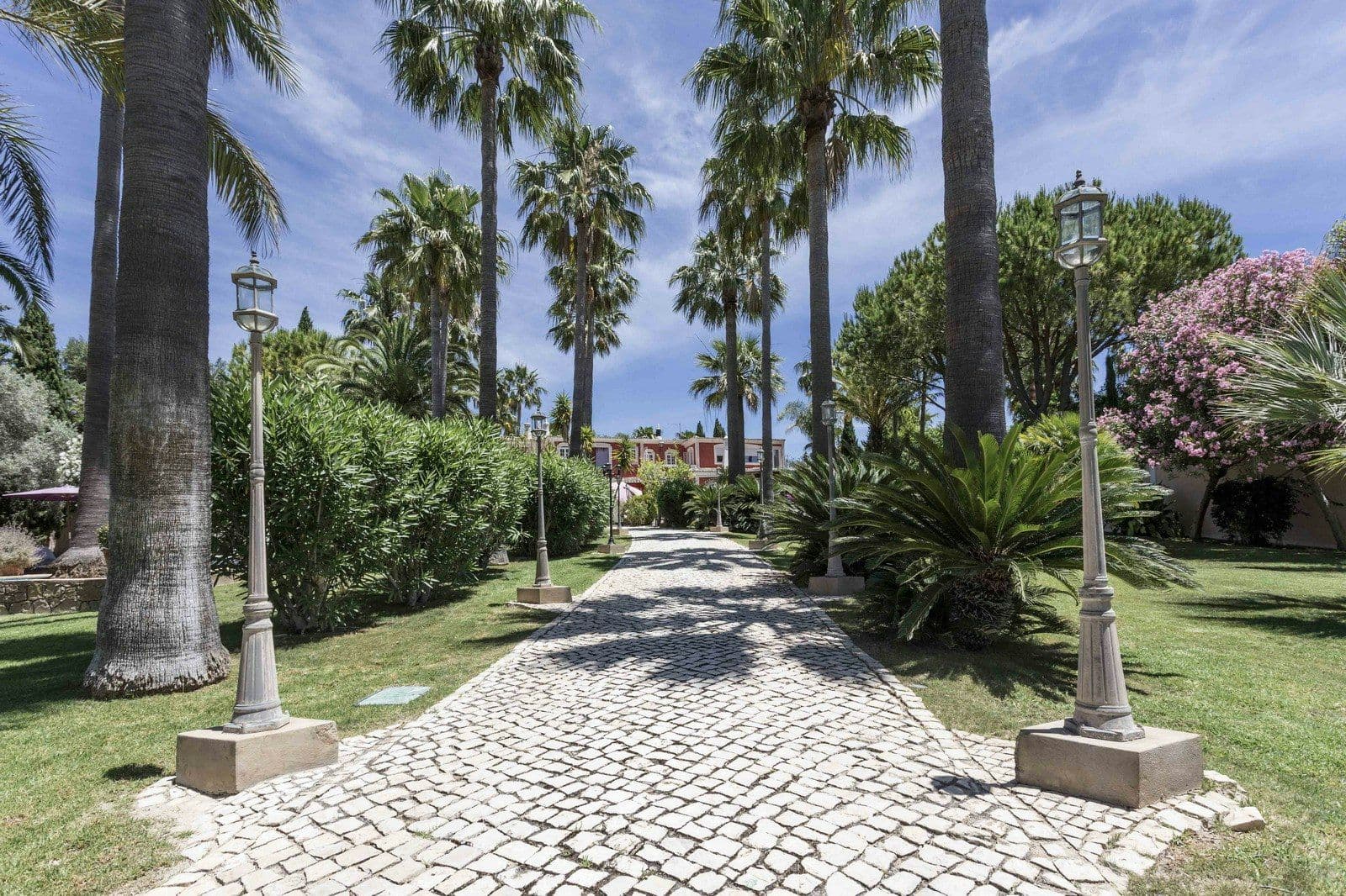 Cobbled avenue lined with palms through the villa gardens at Your Algarve Oasis