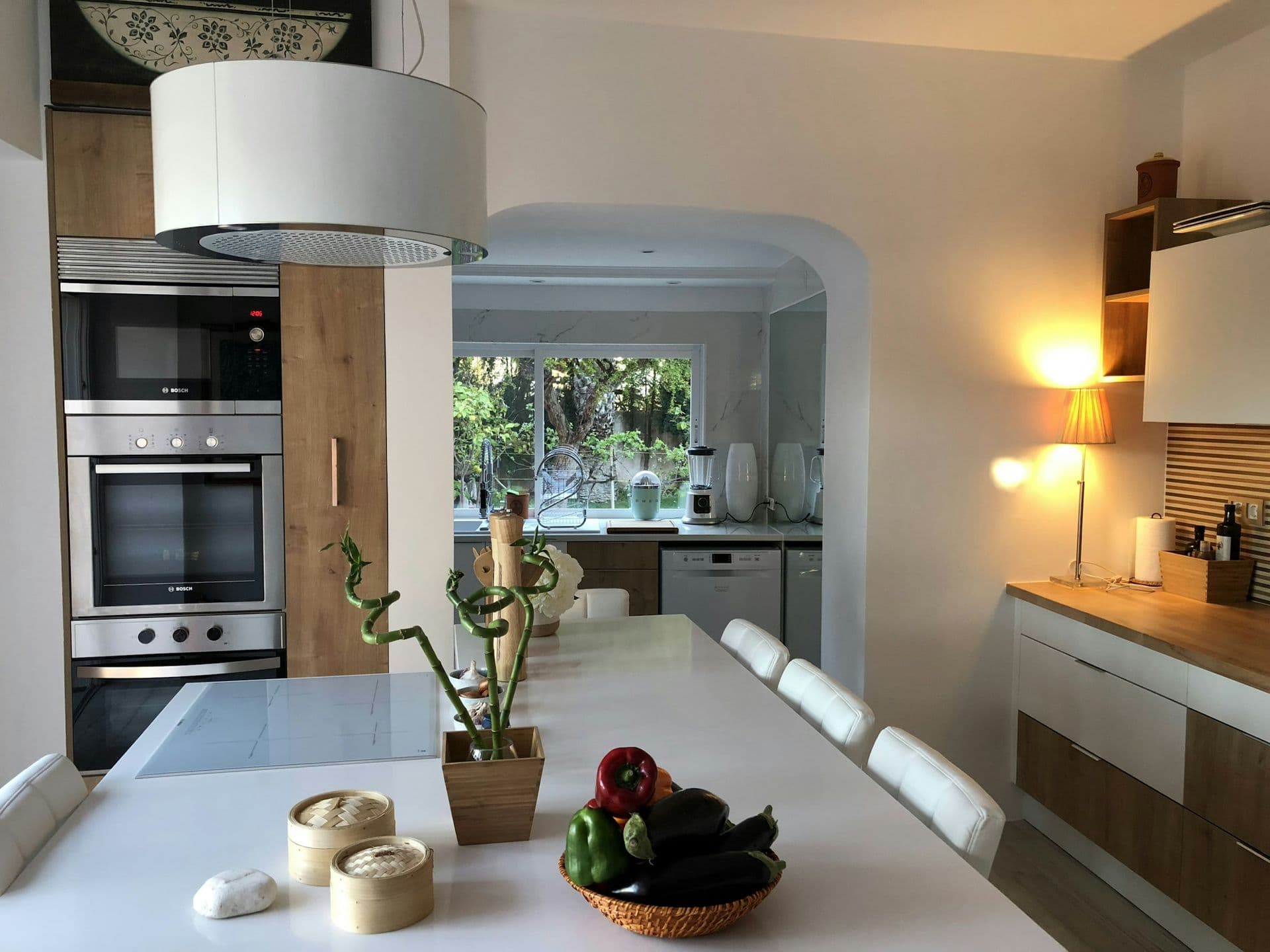 White kitchen with an island and garden outlook at Your Algarve Oasis