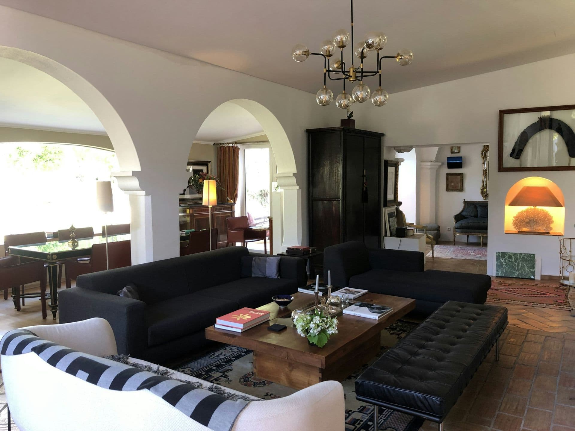 Living room with arched openings and dark sofas at Your Algarve Oasis