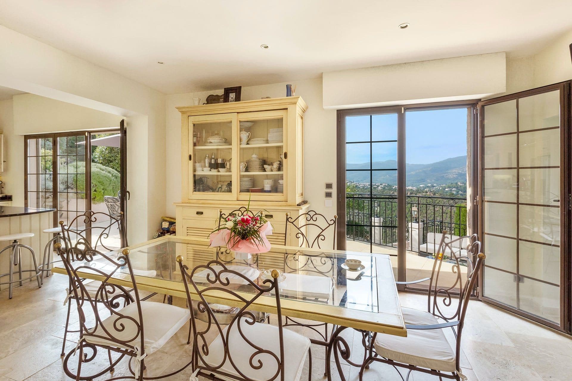 Dining area with wrought-iron table and chairs beside glass doors to the garden