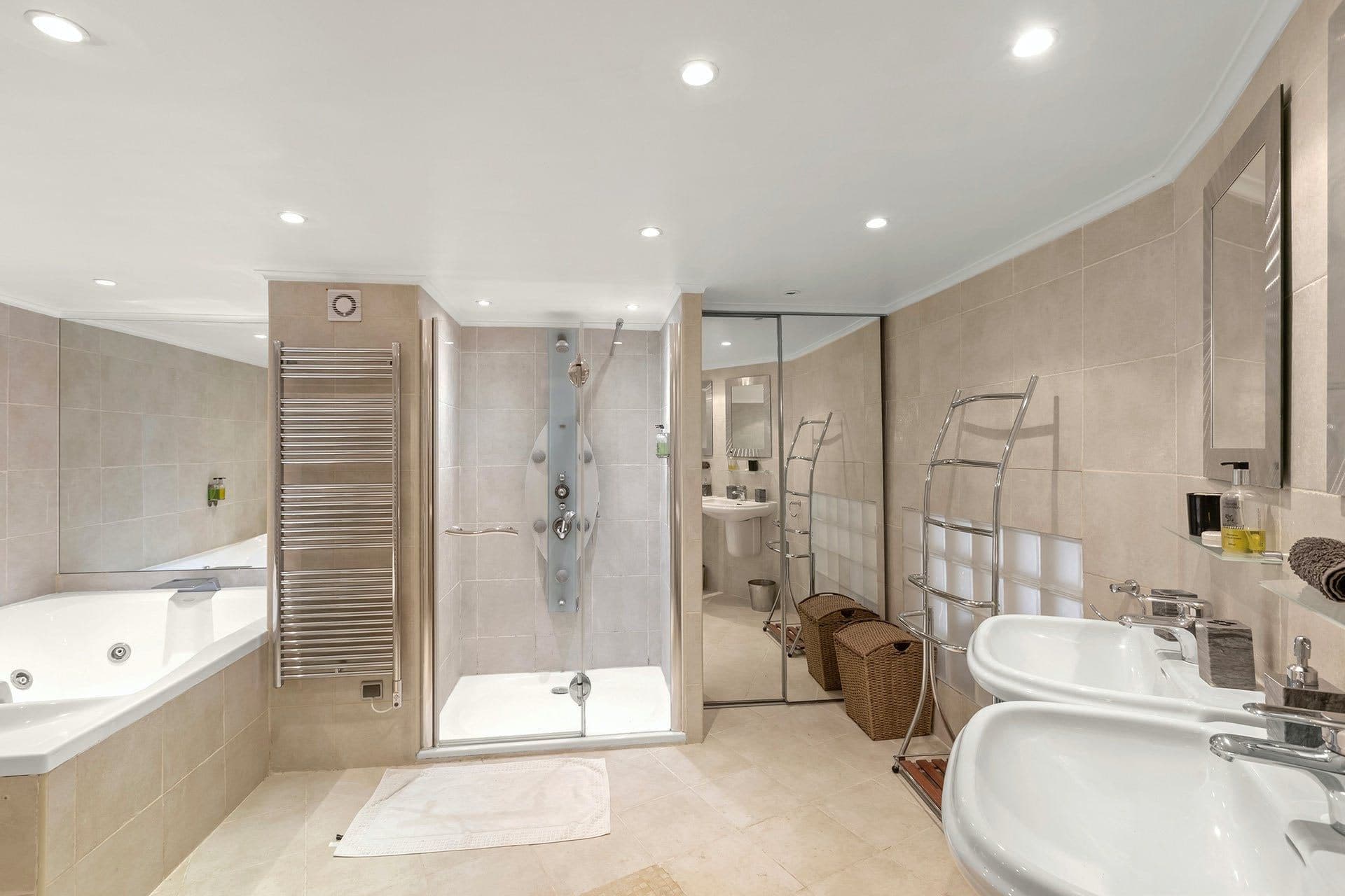 Ensuite bathroom with freestanding tub, walk-in shower and marble-effect tiling
