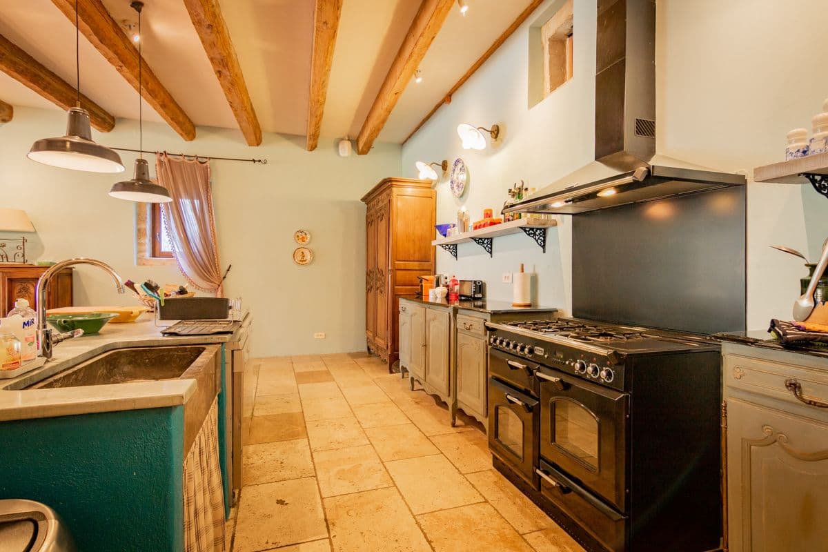 Farmhouse kitchen with dark green cabinetry and range cooker