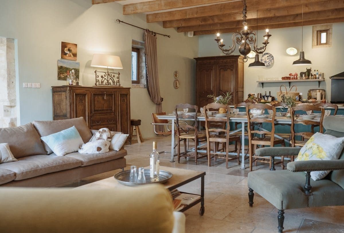 Beamed lounge with sofa and dining table beyond