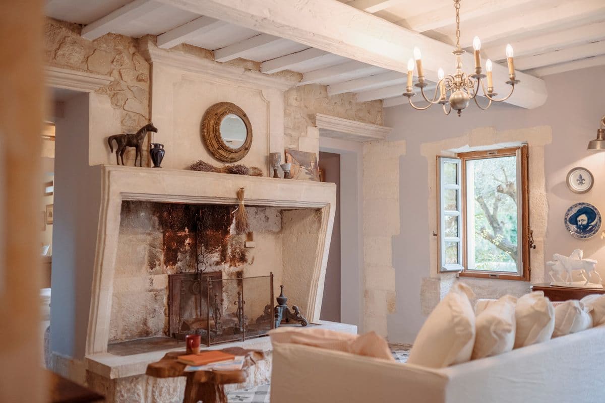 Cosy sitting room with rustic stone fireplace and cream sofa